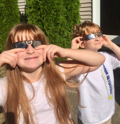 two kids wearing eclipse glasses