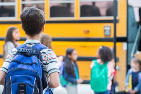 Young boy waits to load school bus