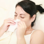 Woman With Cold Sneezing Into Tissue