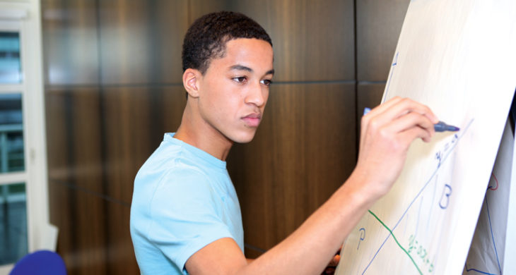 male student working on easel board