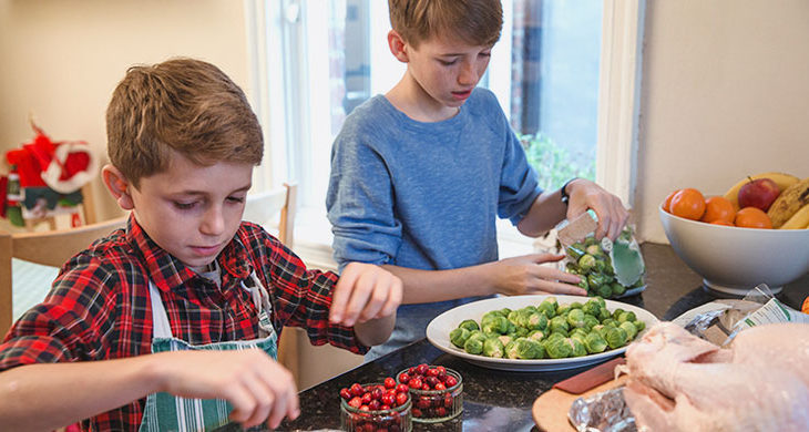 two brothers helping cook thanksgiving meal