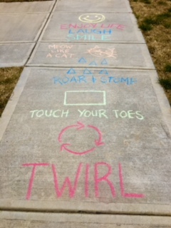 sidewalk with words and shapes drawn with chalk