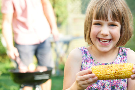 Girl eating corn on the cobb