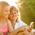 mom and teen looking at cell phone