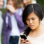 teen being bullied on her cell phone