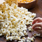 Hands of children eating popcorn