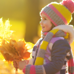 child holding fall leaves