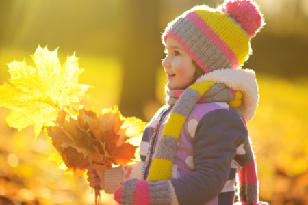 child holding fall leaves