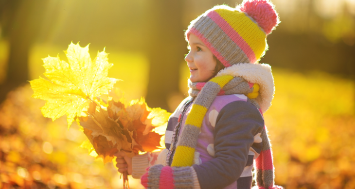 child holding fall leaves