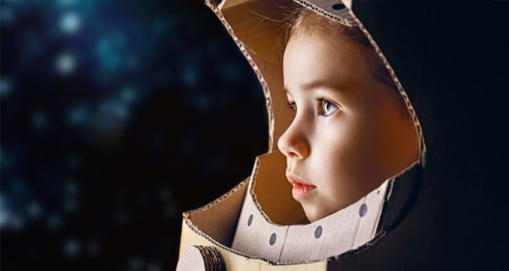 young girl in cardboard astronaut helment