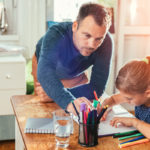 father helping his daughter with homework