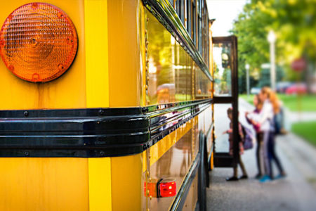 kids getting onto a school bus