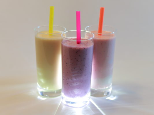 three smoothies in glasses with straws
