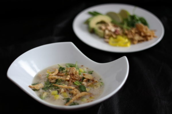 Bowl of chicken and rice soup with garnishes