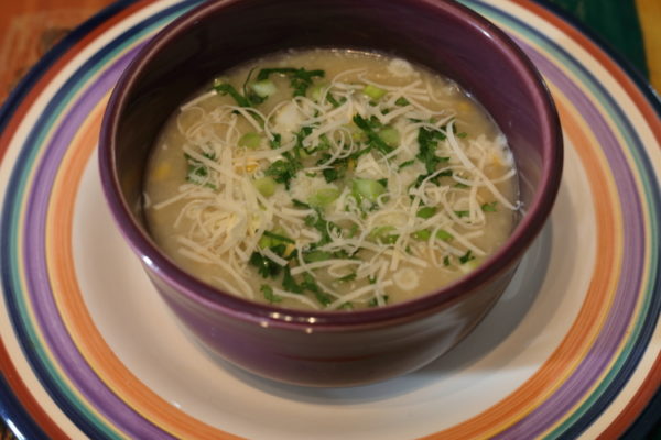 Bowl of potato-cheese soup on multicolored plate