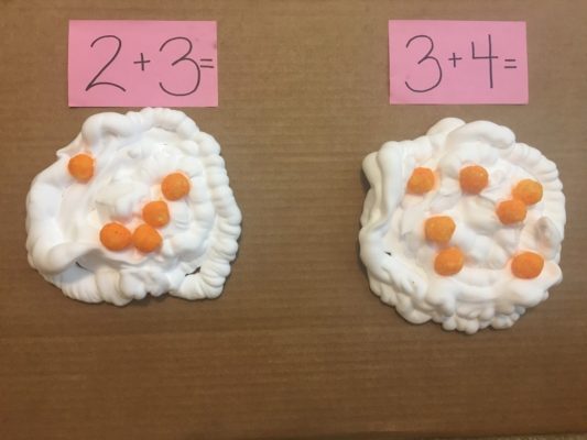 Cheese puffs sitting on shaving cream for math game