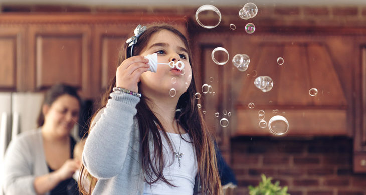little girl playing with bubbles