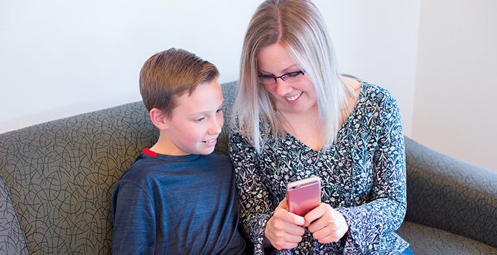 mom showing son app on phone