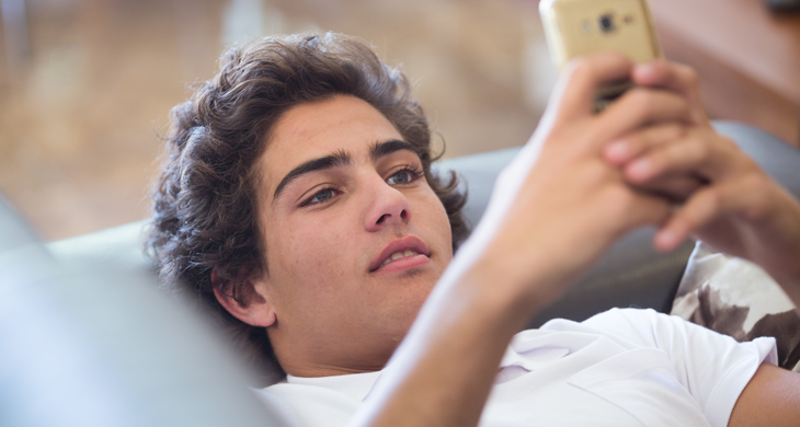 Young Man on Sofa with Cell Phone