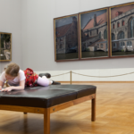 little girl drawing in an art museum