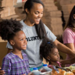 family volunteers together in soup kitchen