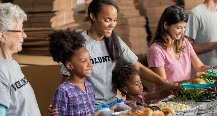 family volunteers together in soup kitchen