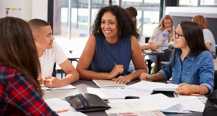 Teacher studying with high school kids