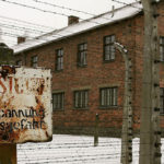 building in Auschwitz camp with old sign
