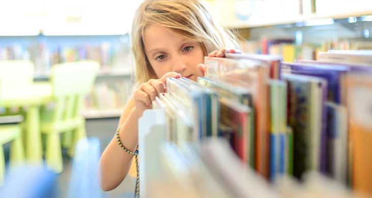 girl looking for a book in a library