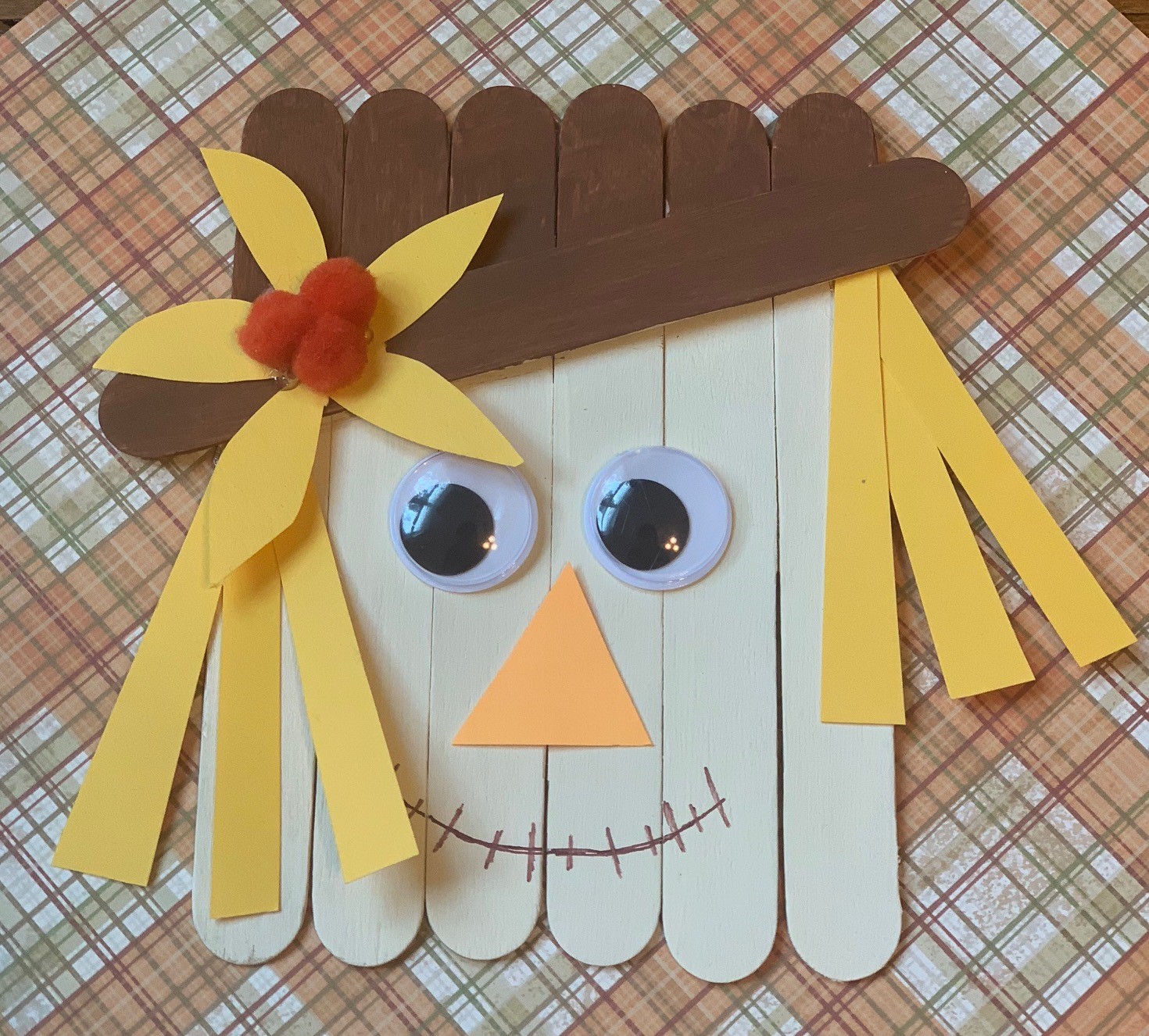scarecrow made out of Popsicle sticks, paint, and paper