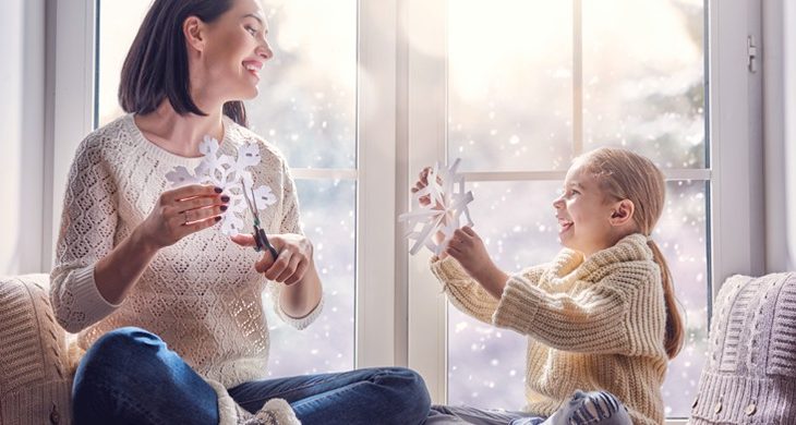 mother and daughter making paper snowflakes
