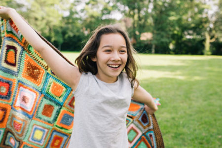 girl running with quilt in unstructured play