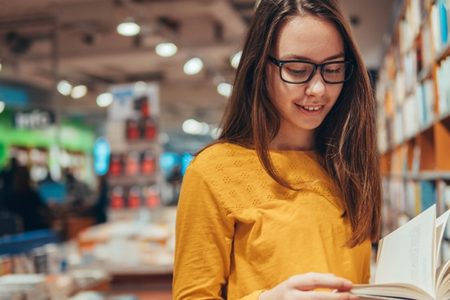 young girl look for books on school reading list