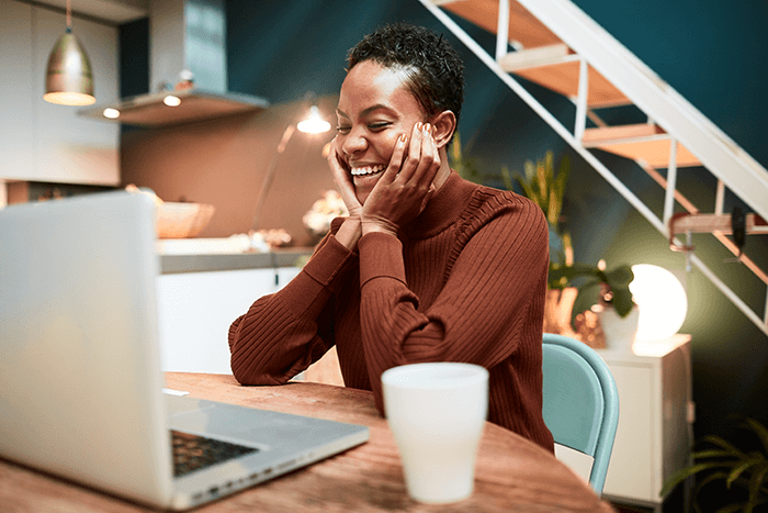 woman happily looking at her laptop