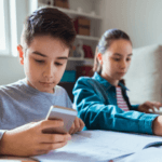 boy and girl independent learning on phone and laptop