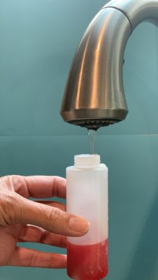 Pouring water into tie dye bottle