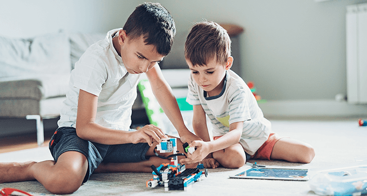 Two boys building a robot