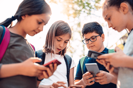 group of kids using cell phones for social media