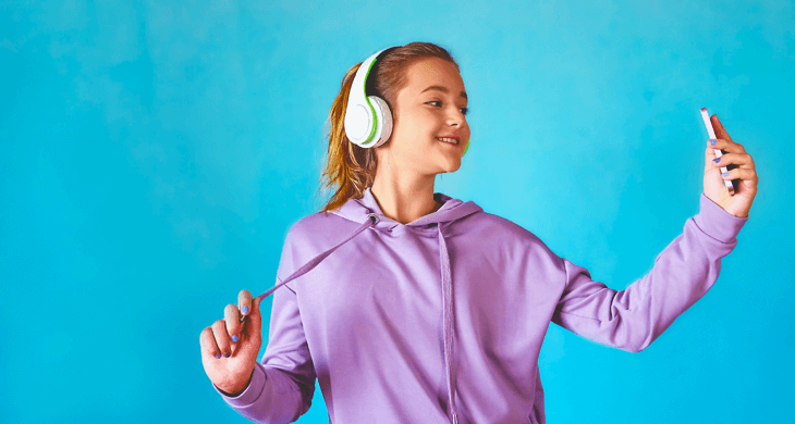 girl with headphones holding smartphone