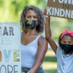 mother and daughter holding protest signs