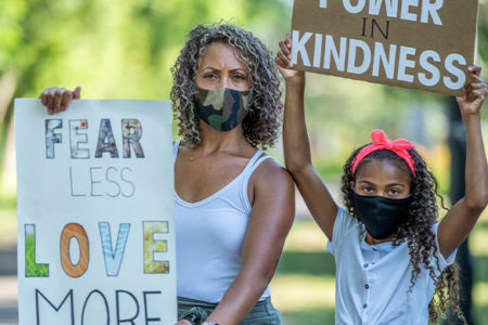 mother and daughter holding protest signs